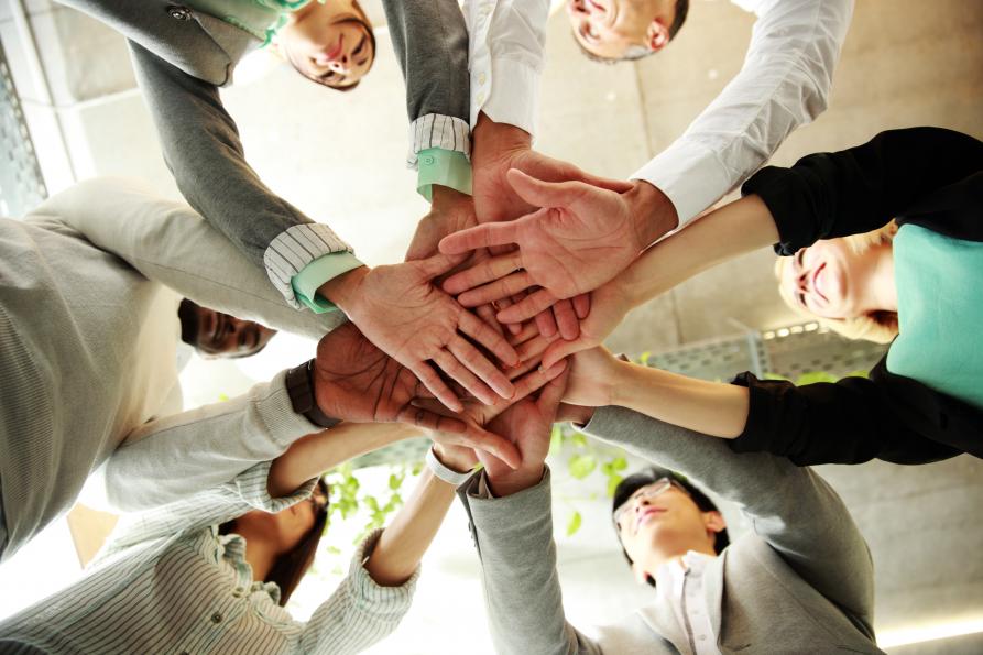Group of 6 people with hands overlapped