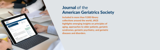 Journal of the American Geriatrics Society; hands and tablet of a person seated at table with other professionals is visible. Screen shows Journal of the American Geriatrics Society